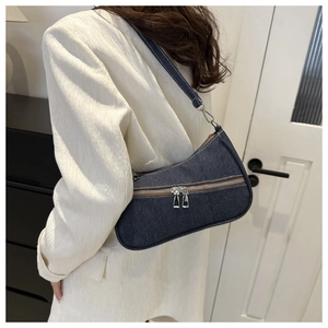Dettaglio della borsa a spalla in denim blu scuro con design a doppia cerniera lampo