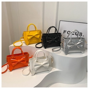 Detailed display of bow-knot crossbody bags in five colors on minimalist tiered stands