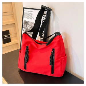 Détail du sac cabas en nylon rouge montrant la texture du tissu et les boucles réglables