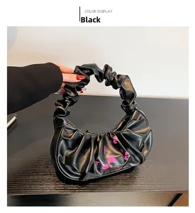 Detail of black cloud bag featuring pleated handle and pink floral print on glossy PU leather