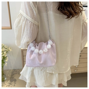 Détail du sac seau plissé lavande avec poignée en perles transparentes et chaîne argentée