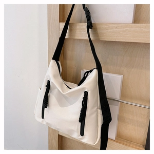 Détail du grand sac cabas en nylon blanc avec fermetures éclair noires et bandoulière