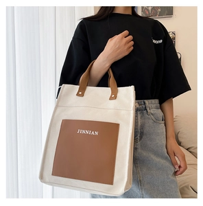 Canvas tote bag with brown pocket shown on a model for a stylish casual commuter look