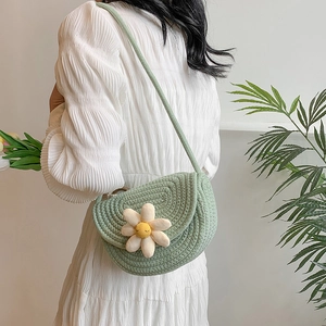Light green knitted shoulder bag with a large daisy accent and a semi-circular flap