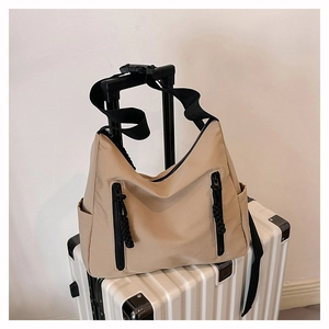 Détail d'un sac fourre-tout en nylon beige avec fermetures éclair sur valise