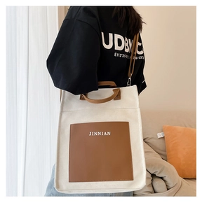 Detail of color block canvas tote bag worn by model in a cozy home interior setting