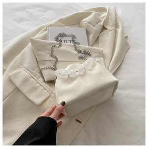 Détail du sac seau en daim blanc avec poignée en perles et bandoulière argentée