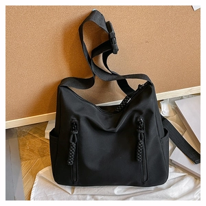 Détail du grand sac cabas en nylon avec poches zippées verticales et tirettes tressées