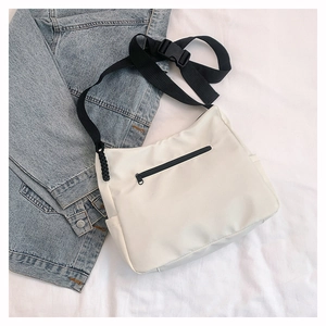 Détail du sac fourre-tout en nylon blanc avec poche zippée noire et sangle réglable