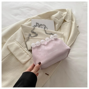 Détail du sac en velours rose clair avec bordure perlée et logo Tidal Dryness