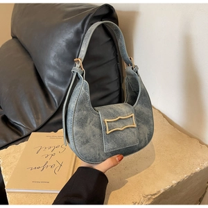 Detail shot of vintage grey-blue denim crescent bag with a gold rectangular buckle