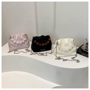 Détail de sacs seaux plissés tendance avec grosse chaîne et poignées en perles