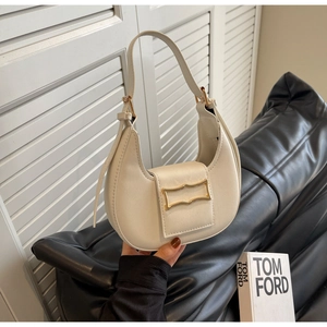 Detailed close-up of white crescent bag featuring a vintage gold metal frame buckle