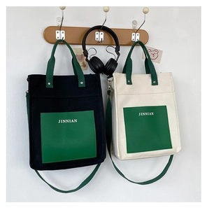 Detail view of canvas tote bags hanging with contrast pockets and shoulder straps