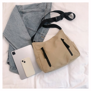 Détail du sac fourre-tout beige en nylon avec double zip et large bandoulière noire
