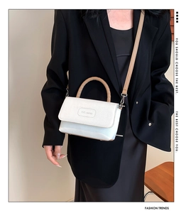 Détail du sac bandoulière en cuir blanc avec poignée tressée et logo Rich Rabbit