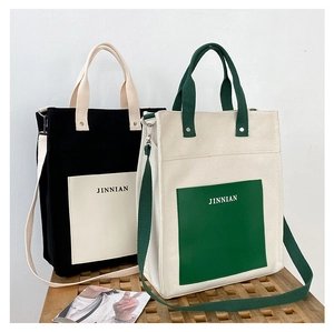 Detail of color-block canvas tote bag with contrast pockets and wide detachable shoulder strap