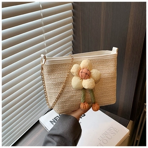 Détail d'un sac seau en paille avec bordure en cuir blanc et décoration florale