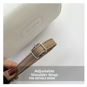 Détail du sac en cuir grainé blanc avec logo et bandoulière réglable en kaki