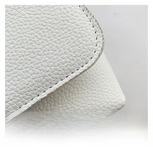 Vue macro de la texture du cuir blanc grainé avec détails de coutures noires