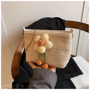 Détail du sac seau en paille tressée avec applique florale et bordure en cuir PU