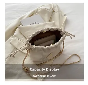 Overhead view showing interior storage space and gold chain strap of cream bucket bag