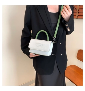 Détail du logo rich rabbit sur le sac bandoulière blanc et vert en cuir à grain lychee
