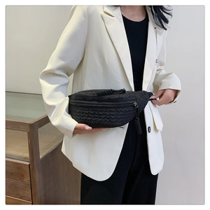 Detail of black quilted wave texture on chest bag with woven zipper and modern design