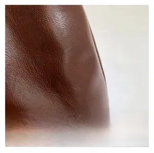 Gros plan sur la texture cuir marron avec motif litchi de ce sac cabas de haute qualité