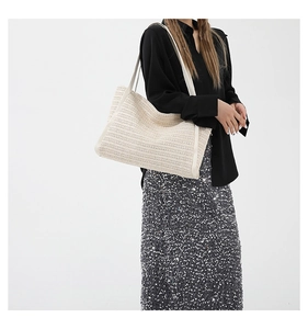 Detail of summer woven tote bag featuring textured contrast weave and wide shoulder straps