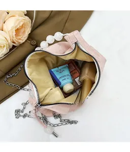 Interior view of pink pleated handbag with pearl handle and spacious storage capacity