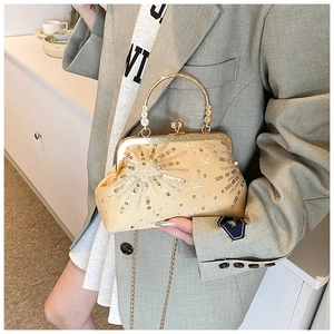 Detail of gold evening clutch bag with sequins, metal handle and vintage clasp