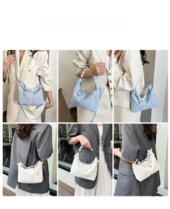 Detail showing pleated cloud handbags in blue and beige with beaded handles and chain strap