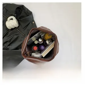 Intérieur spacieux du sac cabas marron contenant une tablette, des livres et parapluie