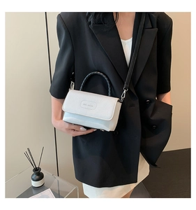 Détail du sac à main en cuir grainé blanc avec logo Rich Rabbit et poignée tressée noire