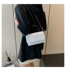 Gros plan sur le cuir grainé blanc et le logo Rich Rabbit sur ce sac à bandoulière
