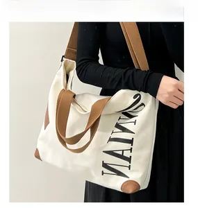 Détail du sac fourre-tout en toile beige avec coins en cuir brun et imprimé MAIWA