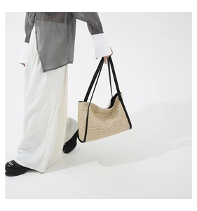 Detail shot of the large woven tote bag showing the black webbing contrast trim and texture