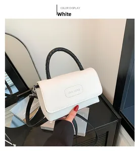 Vue détaillée du sac à bandoulière en cuir blanc avec logo embossé et poignée tressée