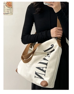 Détail du sac cabas en toile blanche avec imprimé NATURAL et coins en cuir marron renforcés