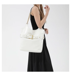 Gros plan du sac cabas blanc brillant avec boucle dorée et détail de bandoulière chaîne