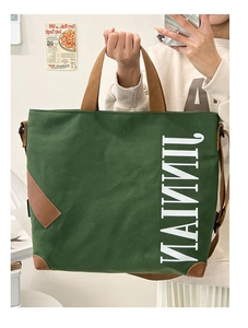 Détail du sac cabas en toile vert forêt avec coins en cuir brun et imprimé 'JINNI'