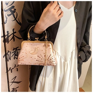 Detailed close-up of pink sequined evening bag with golden metal frame and chain
