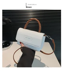Détail du sac blanc en cuir avec poignée tressée marron et logo de rich rabbit