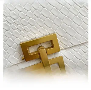 Close-up of woven white leather handbag featuring elegant gold-tone matte metal hardware lock