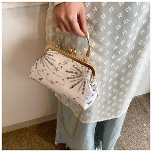 Detail of vintage beaded satin handbag with gold floral handle and sequined pattern
