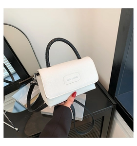 Détail du sac à bandoulière rich rabbit en cuir beige crème avec poignée noire tissée
