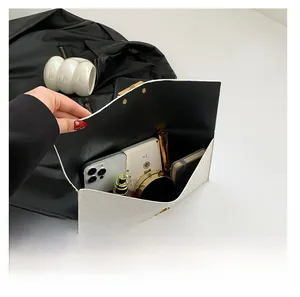 Macro detail of the woven envelope clutch interior showing space for phone and makeup