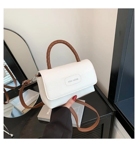 Détail du sac en cuir grainé blanc avec logo Rich Rabbit et poignée tressée marron