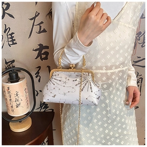 Detailed macro view of white sequin purse with gold metal handle and chain strap